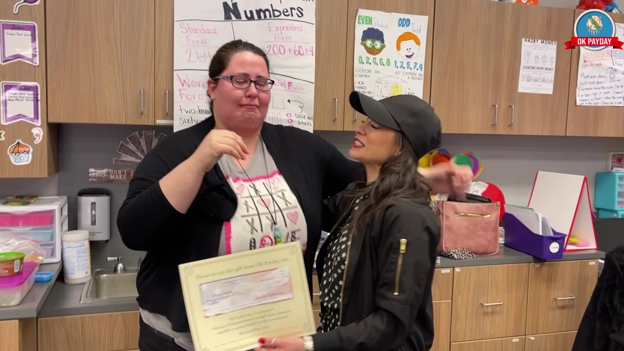 Jannell Hutchison embraces Christie Luttmer during an emotional OK PAYDAY donation presentation, with Brad Gilbert nearby.