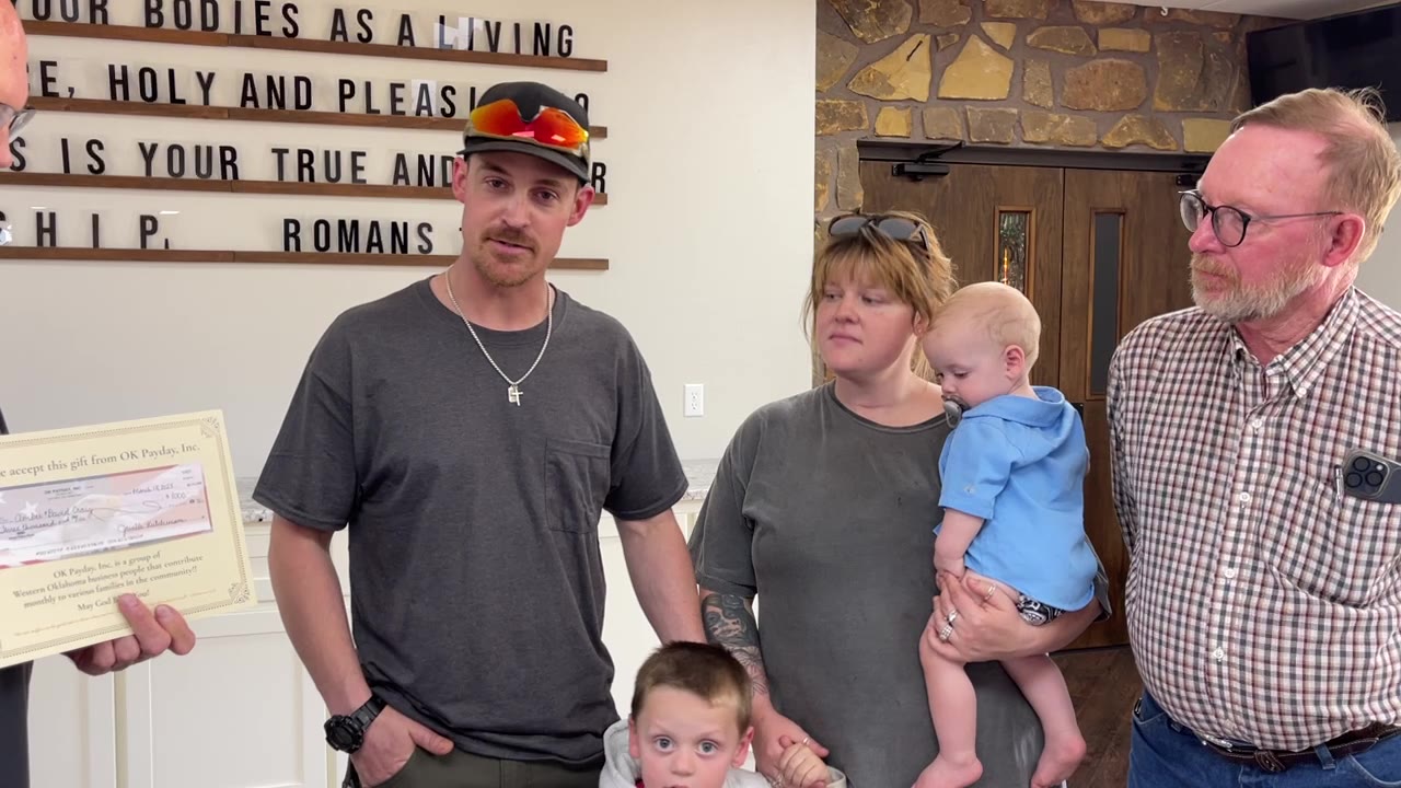 David and Amber Craig with their children Branson and Bodey, accepting a $3,000 check from OK PAYDAY after their home was lost in a fire.